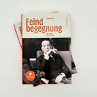 Buchtitel: "Feindbegegnung". Autor: Susanne Falk. Unten ein schwarzes Weißfoto eines Mannes im Anzug mit Zigarette.