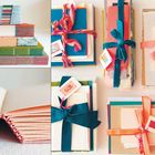 Mehrere Stapel von bunten, gebundenen Büchern und Notizbüchern, einige mit Schleifen gebunden.