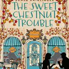 Ein Café mit herbstlichem Dekor, Kürbissen und zwei Personen an einem Tisch. Text: "Sonja Kaiblinger, The Sweet Chestnut Trouble, Roman".