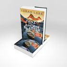 "Tanz der Ahornblätter" von Sarah Lark. Illustration mit Berglandschaft und Kanus auf einem See.