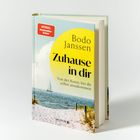 Buchcover: "Zuhause in dir" von Bodo Janssen. Hintergrund zeigt Strand mit Segelboot. Oben links "Spiegel Bestseller-Autor".