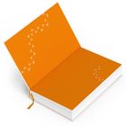 Orange Seiten mit weißen Vogelspuren in einem offenen Notizbuch.
