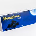 "Mondplaner 2027", "Holga Föger" auf blauem Hintergrund mit Mond und Baum im Vordergrund, spiralförmig gebunden.