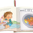 „Maxi hilft beim Wäschemachen. Das sind aber viele Sachen!“ Ein Kind sortiert Kleidung, ein Teddybär sitzt in der Waschmaschine.