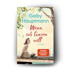 „Gaby Hauptmann: Wenn ich tanzen will. Roman. SPIEGEL Bestseller-Autorin. Eine Frau sitzt auf einem Steg unter einem Baum.“