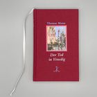 Roter Bucheinband mit Text "Thomas Mann: Der Tod in Venedig" und einer Illustration von Figuren am Wasser.