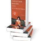 "CHRISTIAN BARON DREI SCHWESTERN", "SPIEGEL Bestseller-Autor", "ROMAN". Bücherstapel, Cover zeigt eine sitzende Frau.