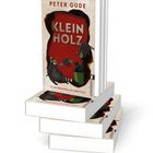 Ein Stapel Bücher mit der Aufschrift "KLEIN HOLZ" und einem Bild von Waschbären auf beigem Hintergrund.