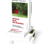 Buchtitel: "Unterm Gras die Knochen". Autoren: Manja Präkels, Daniel Schulz. Bild zeigt Bücherstapel mit rotem Stern im Wald.