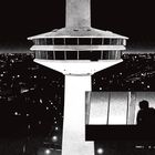 Retro-Illustration eines großen Fernsehturms bei Nacht, darunter eine Silhouette am Fenster.