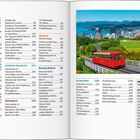 Inhalt: Themen wie Auckland, Northland, Wellington. Bild: rote Standseilbahn in grüner Stadtlandschaft mit Bergen.