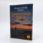 KLAUS-PETER WOLF, Sommerfeldt SOLO, DER AUFTRAG, Ostfriesenkrimi. Silhouette eines Mannes am Strand bei Sonnenuntergang.