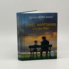 KLAUS-PETER WOLF, ONKEL WARFSMANN und das Meer. Ein Junge und ein Mann auf einer Bank am Meer bei Sonnenuntergang.