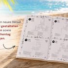 Text: „Jeden Tag ein neues Rätsel mit liebevoll gestalteten Illustrationen sowie Datum, Wochentag und Feiertagen.“. Ein aufgeschlagenes Buch mit Kreuzworträtseln liegt auf einem Tisch am Strand.