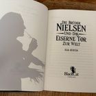 "Die Brüder Nielsen und das Eiserne Tor zur Welt" von Elia Rüstem, BlackCat Verlag. Silhouette einer Person mit Brille.