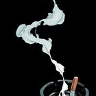 Illustration: Eine brennende Zigarette in einem Aschenbecher mit aufsteigendem Rauch vor schwarzem Hintergrund.