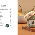 Links steht eine Inhaltsseite mit Projekttiteln und Seitenzahlen. Rechts ein gehäkeltes Gefäß, darauf Kekse und eine Birne.
