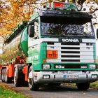 LKW mit den Schildern "Scania", "Ormeloh", "60", "1710", und Nummernschild "COE DS 342". Grüner Lastwagen im Herbst.