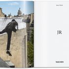 Texte: Janis Mink, JR, TASCHEN. Überdachlandschaft mit riesigem Wandbild einer kletternden Figur.