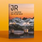 Links: Schwarz-Weiß-Foto der Pariser Skyline mit Eiffelturm, Zügen, Gebäuden und Straßen. Rechts: Text zu Projekten von JR.