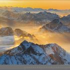 01 | JANUAR. Verschneite Berge im Sonnenuntergang, mit leuchtenden Wolken und klaren Himmelsschichten im Hintergrund.