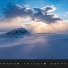 Im unteren Bereich steht „01“, daneben sind die Tage eines Monats aufgelistet. Oben ist eine winterliche Landschaft mit Bergen.