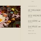 Inhaltsverzeichnis auf beige: LE VILLAGE, LES VIGNES, LA CÔTE, LA VILLE. Links ein Tisch mit Brot und Melonen.