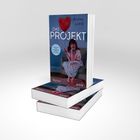 Aufschrift: "DAS PROJEKT" von Annie Lord. Illustration: Frau im Bademantel auf Sofa mit rotem Herzluftballon.