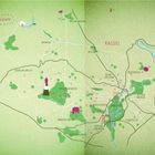 „Glückskarte“ steht oben links. Eine stilisierte Karte mit grünen Flächen, rosa Symbolen und Ortsnamen wie „KASSEL“.