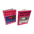 Zwei Bücher "GERMAN POP ART" mit rosa Umschlägen. Cover zeigt Lippenstift-Motiv, einmal bunt, einmal schwarz-weiß.