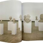 Mehrere abstrakte Büsten auf weißen Sockeln in einem hellen Ausstellungsraum, ohne Texte.