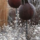 Kalender für Januar 2017. Zwei große, rostige Metallblumen in einem frostigen Garten.