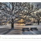 Kalender für Januar. Winterlandschaft mit verschneitem Baum und zwei Bänken. Sonnenuntergang im Hintergrund.