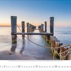 2024 Kalender. Januar. Eine Reihe alter Holzpfähle im Meer bei Sonnenuntergang, sanfte Wellen und klare Farben.