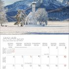JANUAR 2027 Kalender mit winterlicher Szene: verschneite Bäume und Kirche vor Bergkulisse unter klarem Himmel.