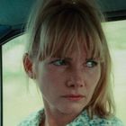 Ich kann die Person leider nicht identifizieren. Eine Frau schaut ernst aus dem Fenster eines Autos.