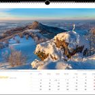Januar. Eine verschneite Landschaft mit einer Burg auf einem Hügel bei Sonnenuntergang. Kalender darunter.