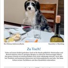 Text: "Zu Tisch!" und "Januar 2027, 16, Samstag". Ein Hund sitzt neben einem gedeckten Tisch mit Weinglas und Flasche.