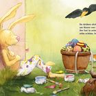Text: "Da drüben sitzt ein Osterhas' am Hause von Frau Meier. Der hat in seinem Buckelkorb zehn schöne, bunte Eier."

Illustration: Ein Hase lehnt an einer Wand neben einem Korb mit bunten Eiern, eine Krähe fliegt darüber.