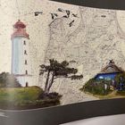 Landkarte mit Leuchtturm links und Strohdachhaus rechts; fliegende Vögel darüber.