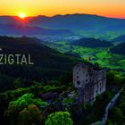 Text: "Romantisches Kinzigtal." Eine Burg über einem grünen Tal bei Sonnenuntergang, im Hintergrund Berge.