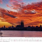 Januar 2027 Kalender mit Kölner Stadtsilhouette im Sonnenuntergang. Dramatische rötliche Wolken über einer Stadtansicht.