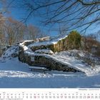 Kalenderblatt Januar 2027. Burgruine im Schnee mit Bäumen, blauem Himmel und einer Bank im Vordergrund.