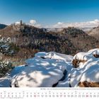 "Die Pfalz - Blick vom Slevogtfels bei Annweiler am Trifels mit Burgruine Scharfenberg, Anebos und Burg Trifels."   
Winterlandschaft mit bewaldeten Hügeln und schneebedeckten Felsen.