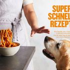 Text: "SUPERSCHNELLE REZEPTE. Acht Rezepte, die in maximal 15 Minuten fertig sind. Eins für jeden Tag der Woche, plus eins in Reserve!"  
Eine Person serviert Nudeln; ein Hund schaut hoch.