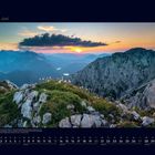 06 Juni. Kalenderseite. Ein Bergpanorama im Sonnenuntergang mit grüner Wiese und Felsen im Vordergrund.