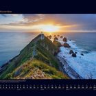 11 November. Küstenlandschaft bei Sonnenuntergang. Ein Weg führt zu einem Leuchtturm auf einer Klippe. Kalenderansicht unten.