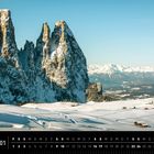 Ein Kalender mit Schneelandschaft, majestätischen Bergen der Dolomiten und vereinzelten Hütten im Schnee.