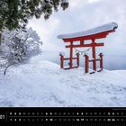 Japan 01. Januar. Schneebedeckter Schrein torii, Bäume und ruhiger See im Hintergrund.