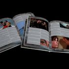 Ein geöffnetes Magazin mit Bildern von Filmszenen und Textabschnitten darüber.